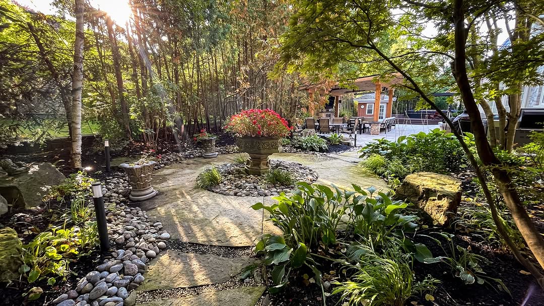 Beautiful landscaped backyard with stone pathways, decorative planters, and lush greenery