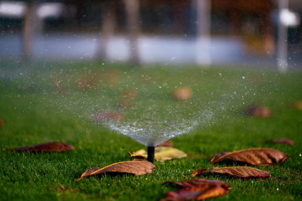 Sprinkler watering green lawn on the ground